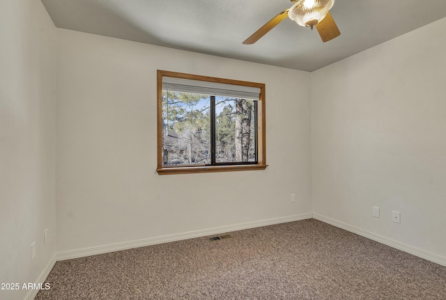 empty room featuring a ceiling fan, visible vents, carpet, and baseboards