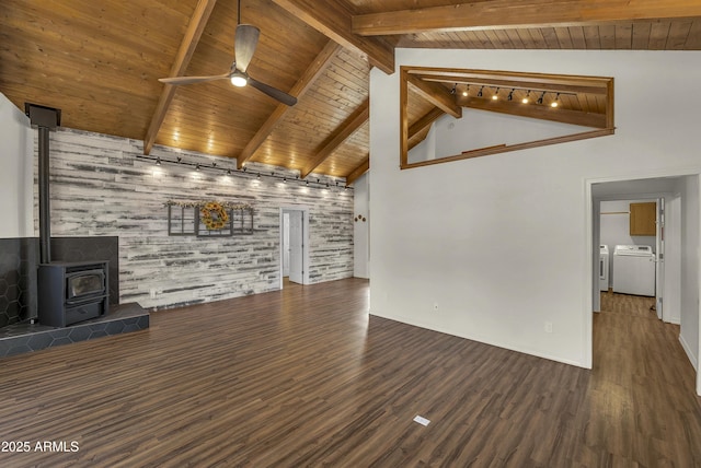 unfurnished living room featuring wooden ceiling, a wood stove, ceiling fan, and separate washer and dryer