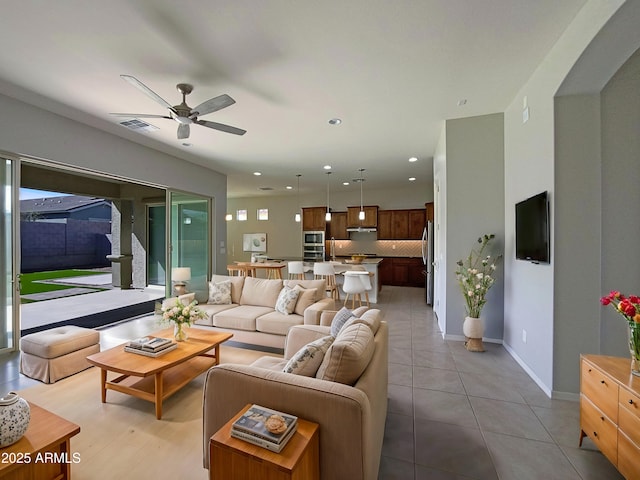 living room with light tile patterned floors, visible vents, baseboards, a ceiling fan, and recessed lighting