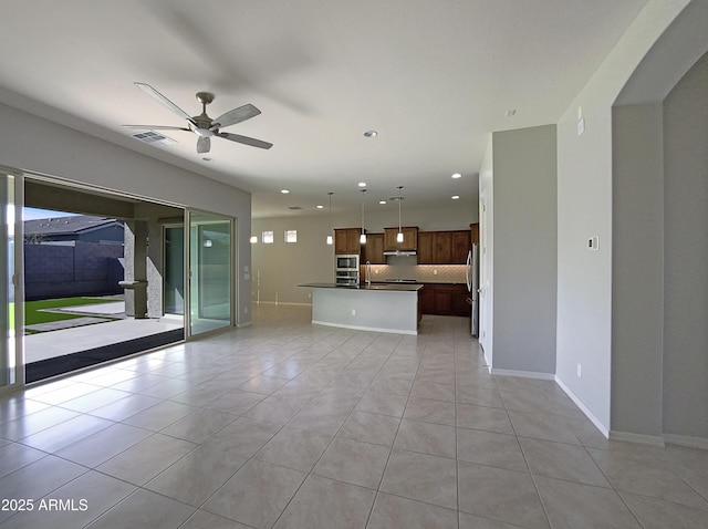 unfurnished living room with light tile patterned floors, ceiling fan, recessed lighting, visible vents, and baseboards