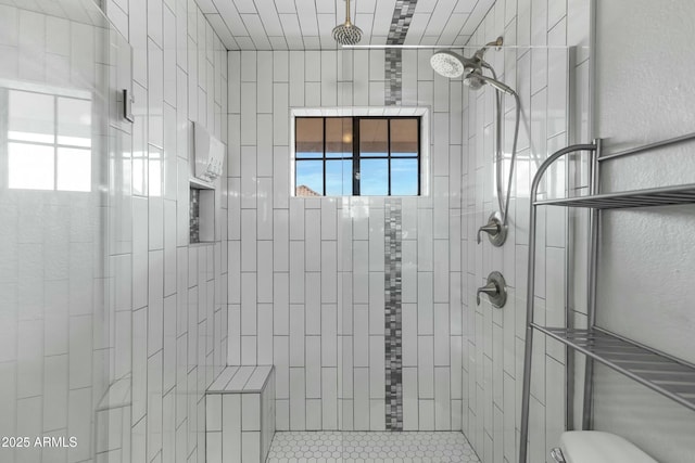 bathroom with plenty of natural light and tiled shower