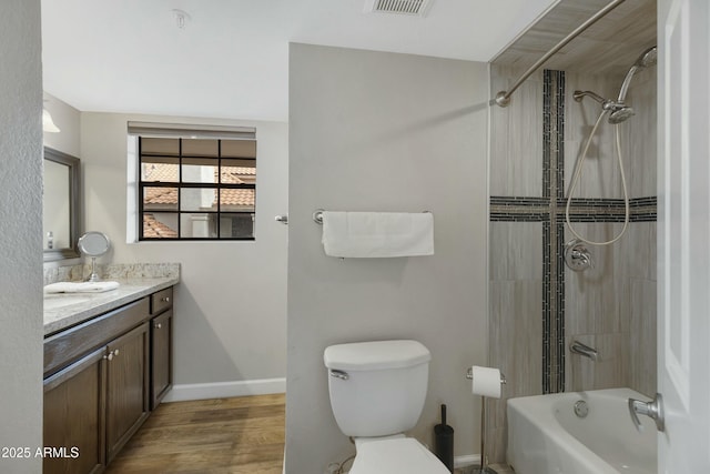 full bathroom featuring vanity, toilet, tiled shower / bath combo, and hardwood / wood-style floors