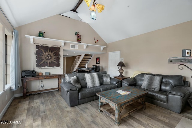 living room with hardwood / wood-style flooring and high vaulted ceiling