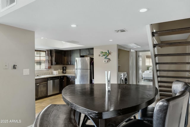 dining space featuring washer and dryer and light wood-type flooring