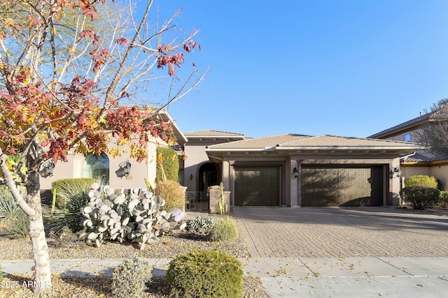 view of front of property with a garage, decorative driveway, and stucco siding