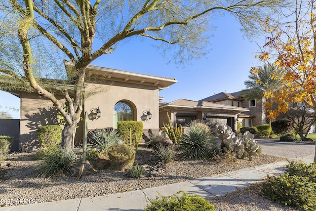 view of front of home with a garage, driveway, and stucco siding