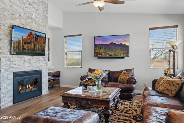 19023 E Buckskin Ct, Rio Verde, AZ 85263 - living room featuring vaulted ceiling, wood finished floors, a stone fireplace, baseboards, and ceiling fan