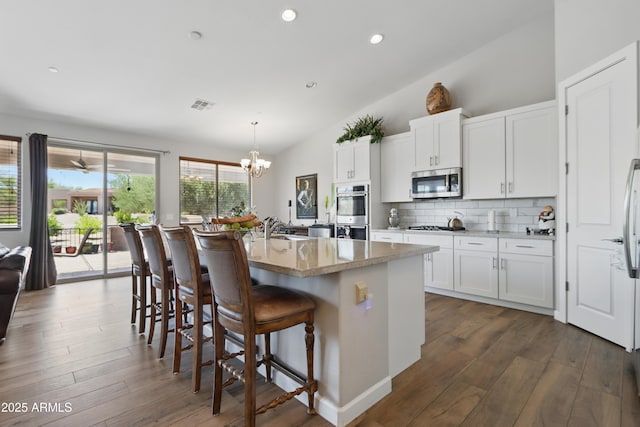 19023 E Buckskin Ct, Rio Verde, AZ 85263 - kitchen with white cabinets, appliances with stainless steel finishes, vaulted ceiling, backsplash, and a notable chandelier