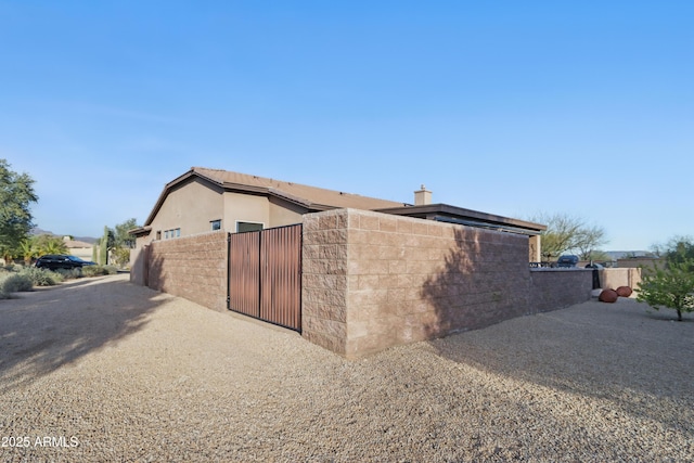 19023 E Buckskin Ct, Rio Verde, AZ 85263 - view of property exterior featuring stucco siding, a gate, and fence
