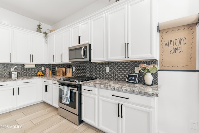 1492 W Bruce Ave, Gilbert, AZ 85233 - kitchen with appliances with stainless steel finishes, backsplash, white cabinets, light stone countertops, and light wood finished floors