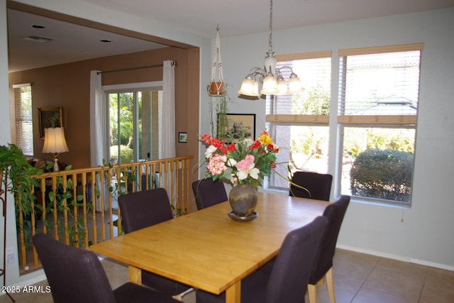 dining space with baseboards, tile patterned flooring, visible vents, and a notable chandelier