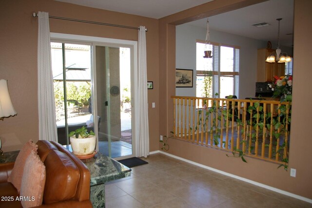 doorway with light tile patterned floors, visible vents, baseboards, and an inviting chandelier