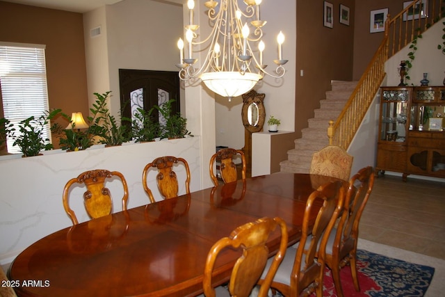 tiled dining room featuring a chandelier, french doors, and stairway