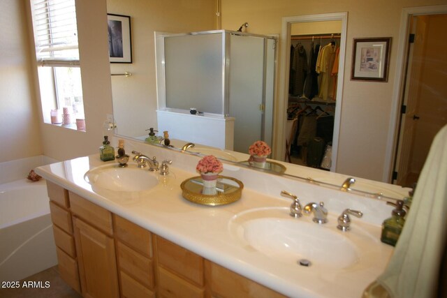 bathroom featuring double vanity, a sink, a shower stall, and a bath