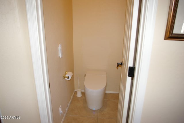 bathroom with baseboards, toilet, and tile patterned floors