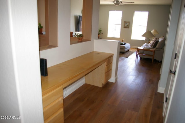 hallway featuring baseboards and wood finished floors