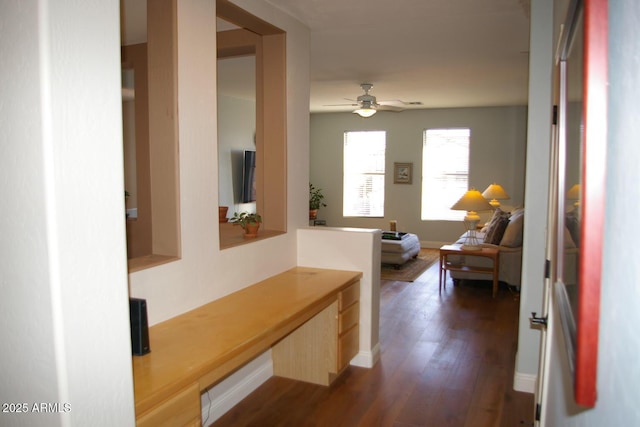 hallway with dark wood-type flooring and baseboards