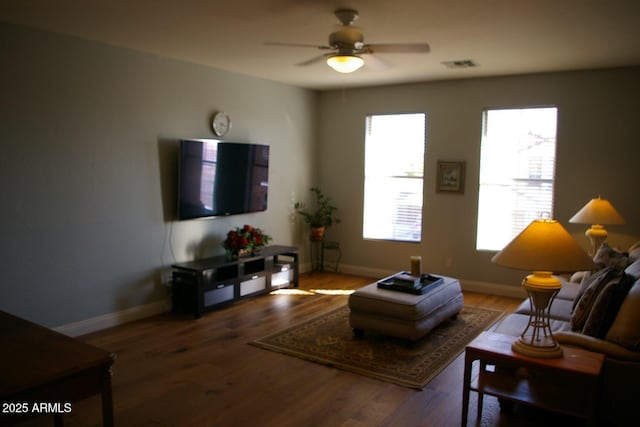 living area featuring a ceiling fan, wood finished floors, visible vents, and baseboards