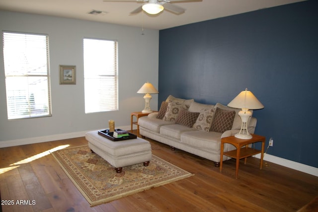 living room featuring a wealth of natural light, wood finished floors, visible vents, and baseboards