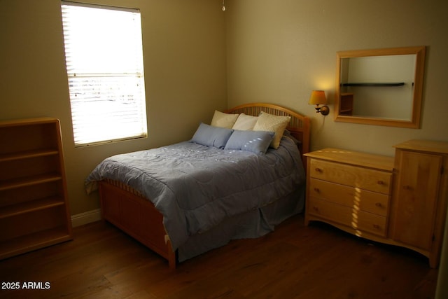 bedroom featuring wood finished floors and baseboards