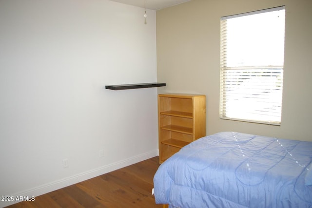 bedroom featuring baseboards and wood finished floors