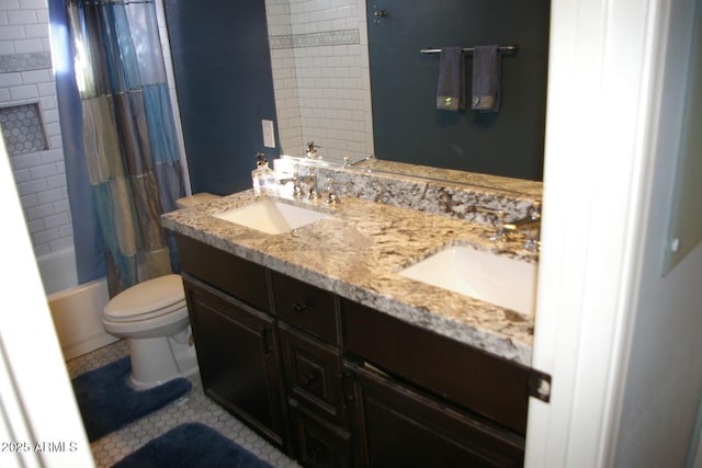 bathroom with double vanity, shower / tub combo, a sink, and toilet