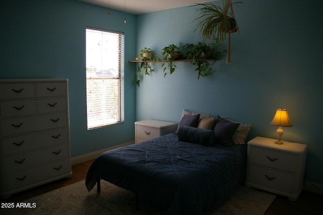 bedroom featuring baseboards and wood finished floors