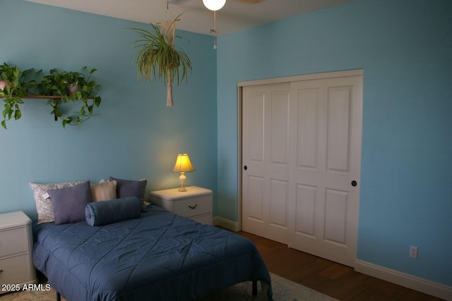 bedroom with a closet, wood finished floors, and baseboards