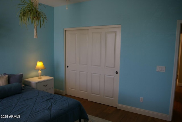 bedroom featuring baseboards, a closet, and wood finished floors