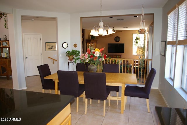 dining area featuring an inviting chandelier, light tile patterned floors, and baseboards