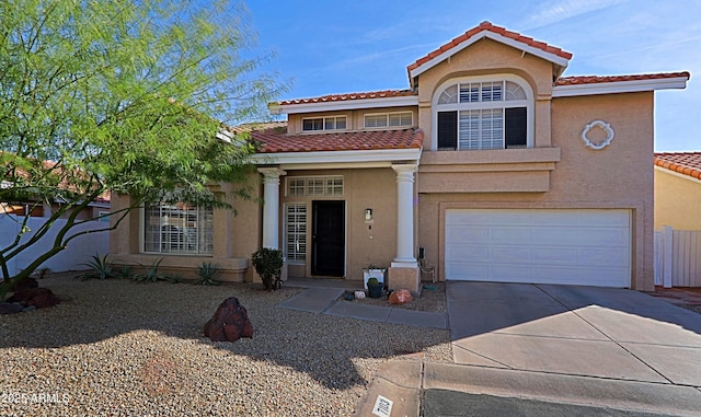 mediterranean / spanish-style home with concrete driveway, a tile roof, and stucco siding