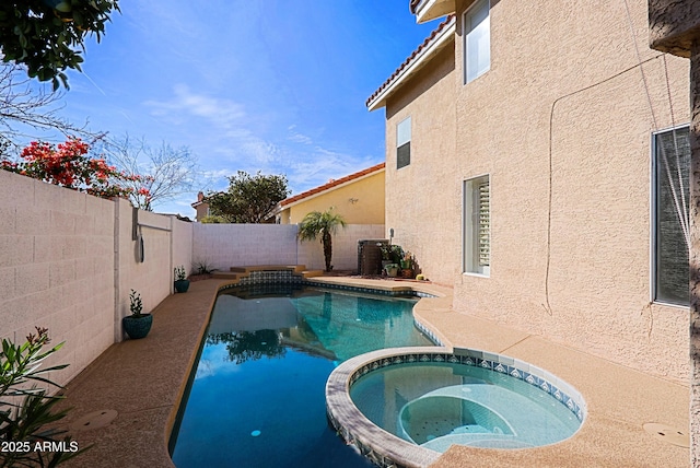 view of swimming pool featuring a fenced backyard and a pool with connected hot tub