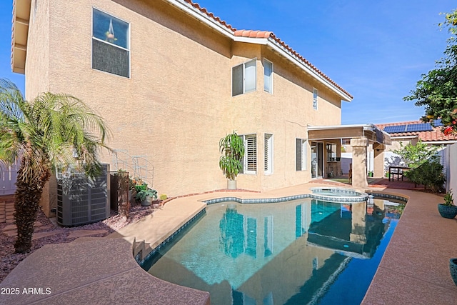 view of pool featuring central AC, a patio, fence, and a pool with connected hot tub