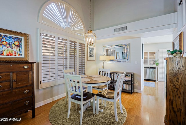 dining area with baseboards, a notable chandelier, visible vents, and light wood-style floors