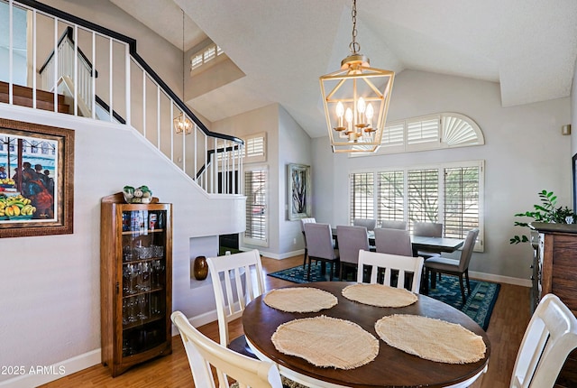 dining area featuring beverage cooler, baseboards, wood finished floors, and a notable chandelier