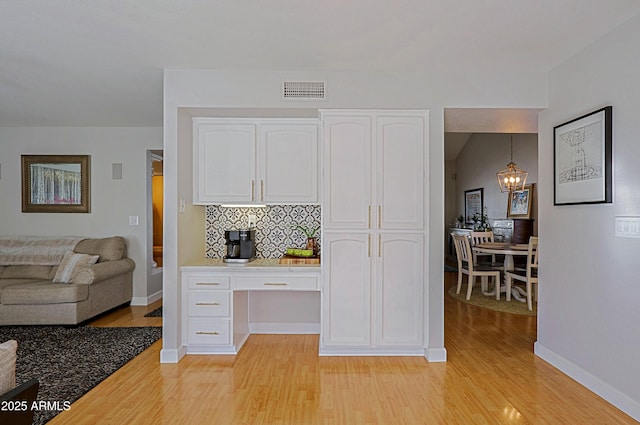 kitchen featuring white cabinetry, pendant lighting, and light countertops