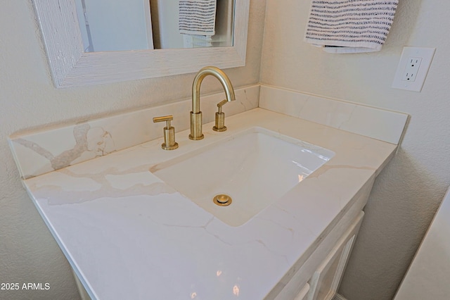 bathroom featuring a textured wall and vanity