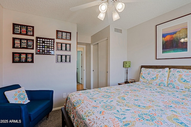 carpeted bedroom featuring baseboards, visible vents, a ceiling fan, a textured ceiling, and a closet