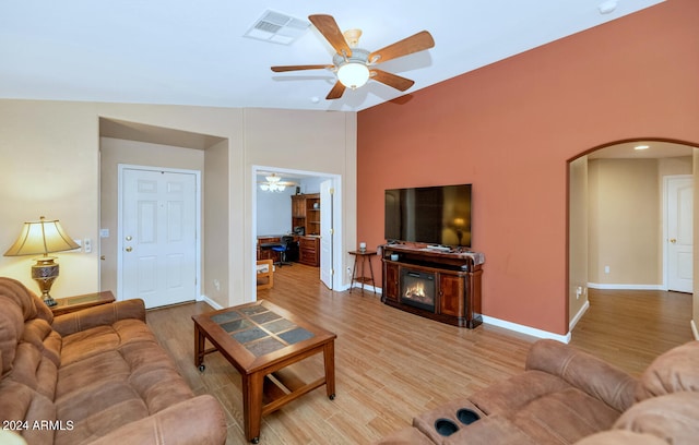 living room featuring ceiling fan, vaulted ceiling, and light hardwood / wood-style floors