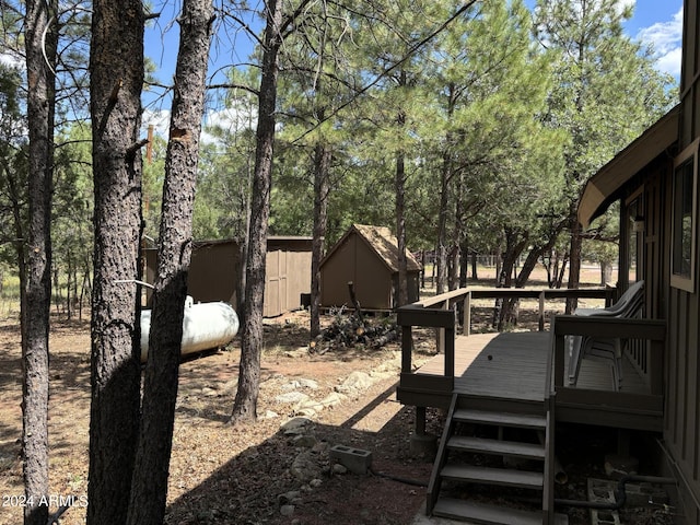 view of yard featuring a storage shed and a wooden deck