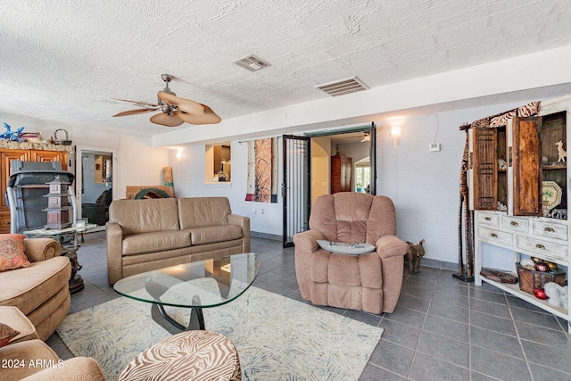 tiled living room with ceiling fan and a textured ceiling