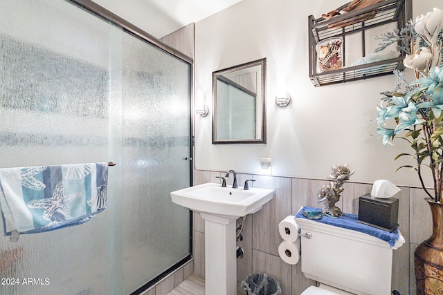 bathroom featuring toilet and an enclosed shower