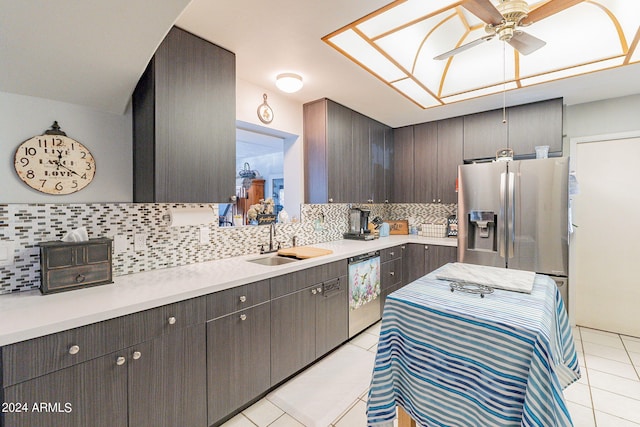 kitchen with decorative backsplash, dark brown cabinetry, stainless steel appliances, sink, and light tile patterned floors