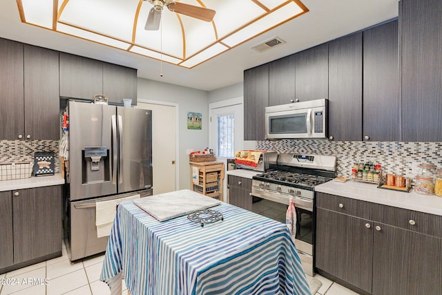 kitchen featuring decorative backsplash, ceiling fan, light tile patterned flooring, and appliances with stainless steel finishes