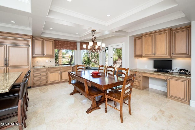 dining space with built in desk, a healthy amount of sunlight, an inviting chandelier, and ornamental molding