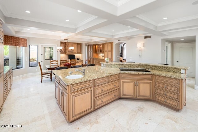 kitchen featuring a large island, light stone countertops, a chandelier, pendant lighting, and sink