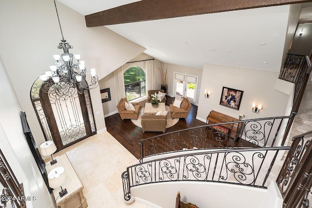 entrance foyer featuring vaulted ceiling with beams, wood-type flooring, and an inviting chandelier