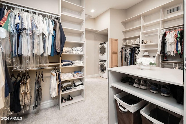 spacious closet with carpet flooring and stacked washer / drying machine