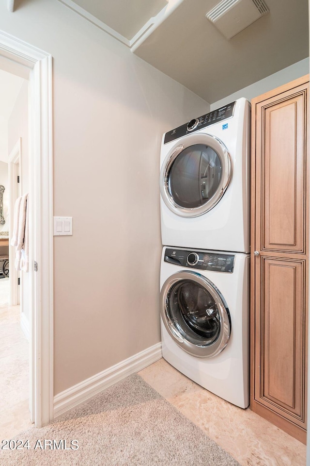 clothes washing area with stacked washer and dryer