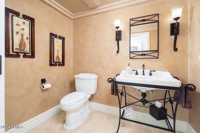 bathroom with tile patterned floors, toilet, and ornamental molding